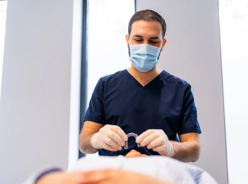 Dr Cihan Babayigit présentant des aligneurs orthodontiques au cabinet